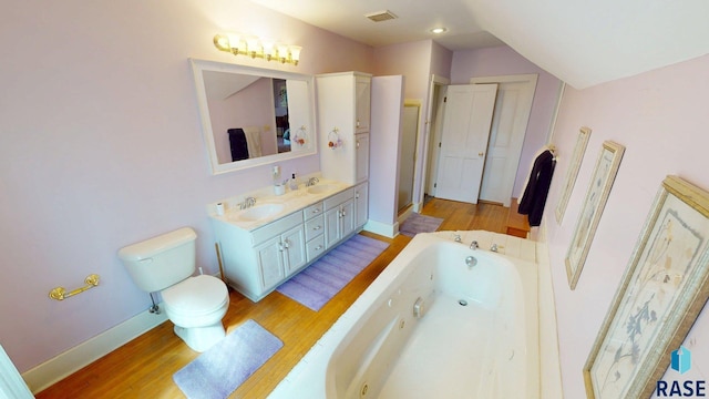 712 6th St, Brookings, SD 57006 - bathroom featuring wood finished floors, visible vents, a jetted tub, and a sink