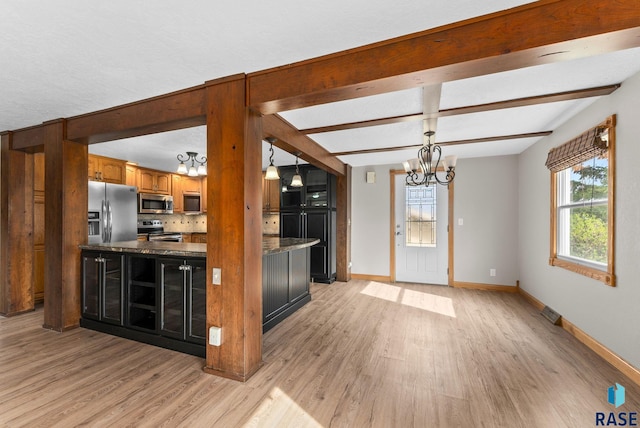 kitchen with appliances with stainless steel finishes, light wood-style flooring, a notable chandelier, and baseboards