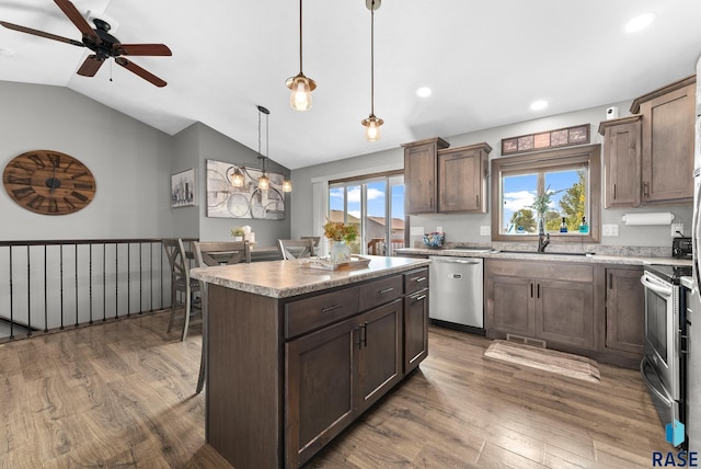 kitchen featuring plenty of natural light, stainless steel appliances, a kitchen island, and a sink