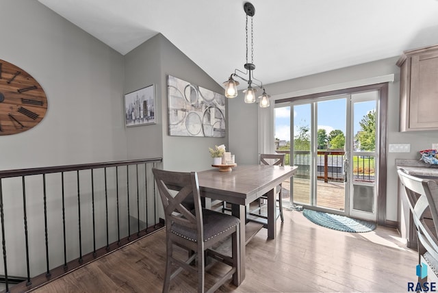 dining room with wood finished floors and vaulted ceiling
