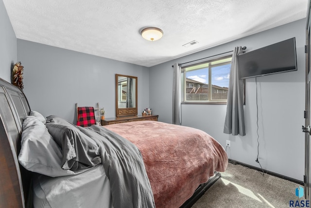 carpeted bedroom with visible vents and a textured ceiling