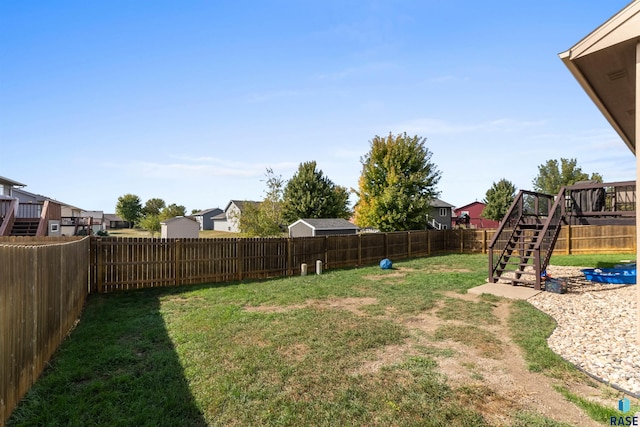 view of yard with a wooden deck, stairway, a residential view, and a fenced backyard