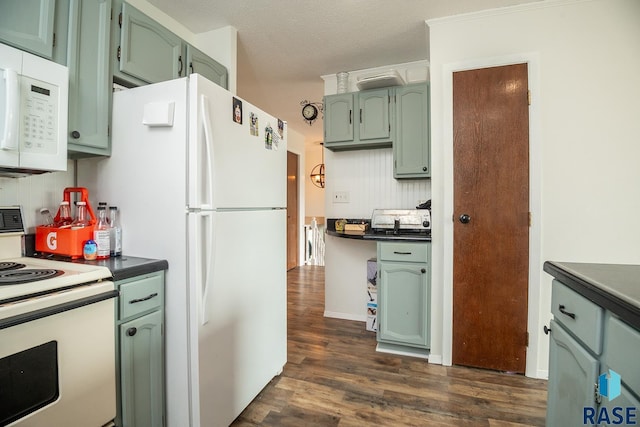 kitchen with white appliances, green cabinetry, and dark wood-style floors