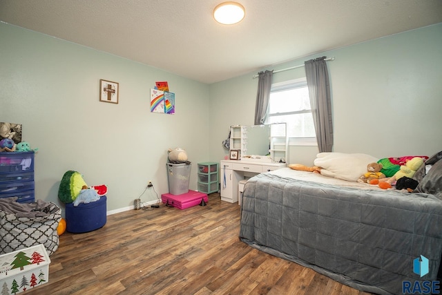 bedroom with baseboards and wood finished floors