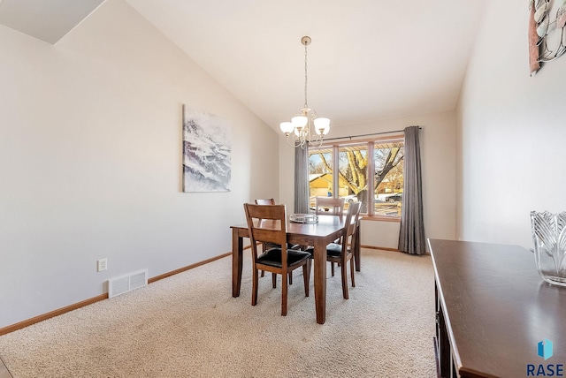 dining area featuring light colored carpet, vaulted ceiling, baseboards, visible vents, and a notable chandelier