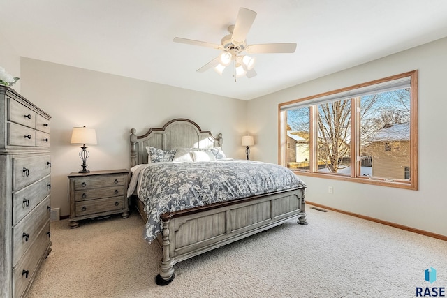 bedroom featuring a ceiling fan, visible vents, light carpet, and baseboards
