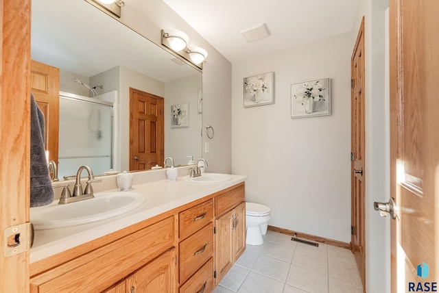 bathroom featuring a sink, a shower stall, tile patterned floors, and visible vents