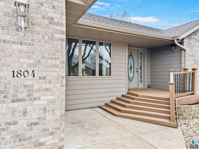 doorway to property featuring a shingled roof