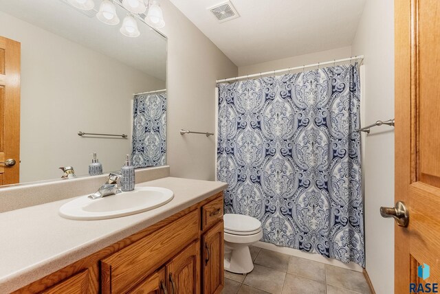 bathroom featuring visible vents, tile patterned flooring, toilet, vanity, and curtained shower