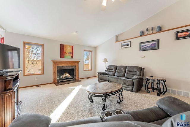 living area with a premium fireplace, a healthy amount of sunlight, baseboards, and carpet floors