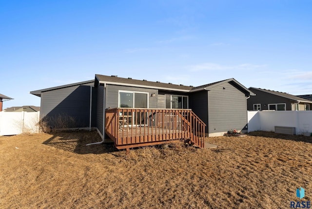 back of house with a deck and fence