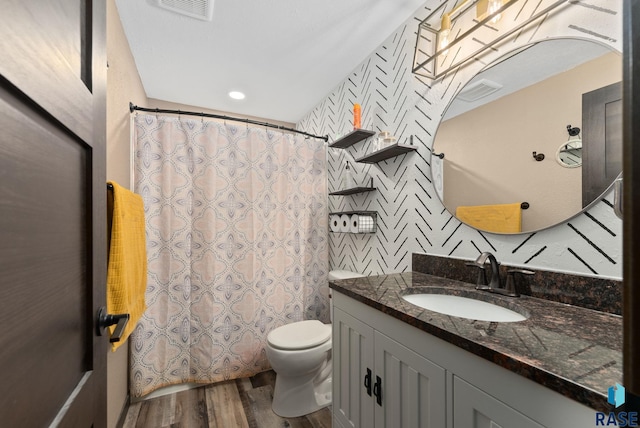 bathroom with wood finished floors, toilet, curtained shower, vanity, and visible vents