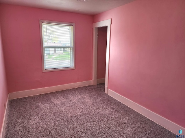 carpeted empty room featuring baseboards