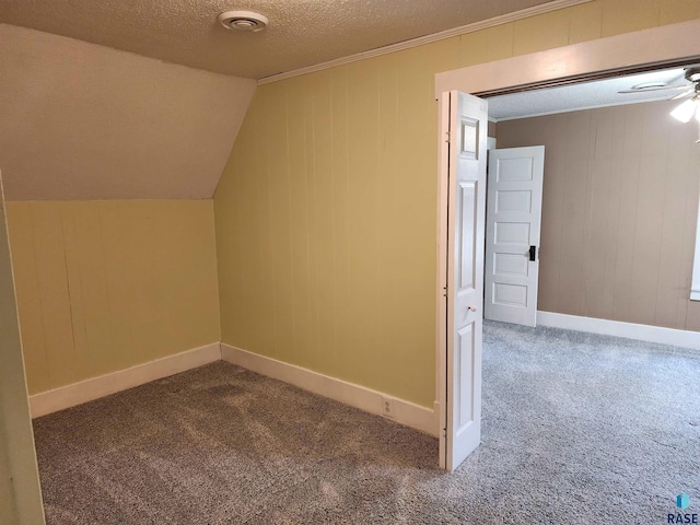 additional living space featuring lofted ceiling, a textured ceiling, carpet flooring, baseboards, and a ceiling fan