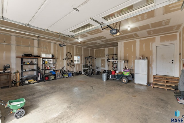 garage with a garage door opener and freestanding refrigerator