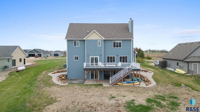 rear view of house with a patio, a chimney, a deck, a lawn, and stairway