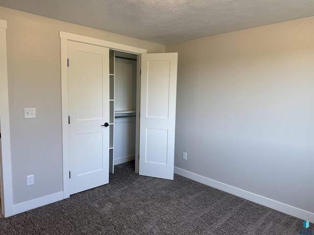 301 W 2nd St, Marion, SD 57043 - unfurnished bedroom with baseboards, dark carpet, and a closet