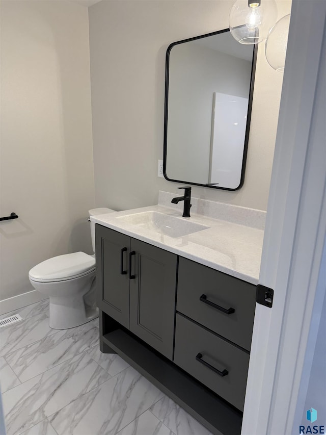301 W 2nd St, Marion, SD 57043 - half bathroom featuring vanity, toilet, marble finish floor, visible vents, and baseboards