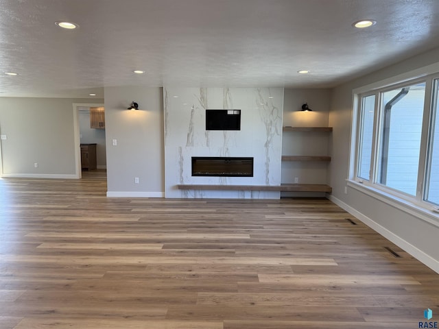 301 W 2nd St, Marion, SD 57043 - unfurnished living room with a fireplace, recessed lighting, and baseboards