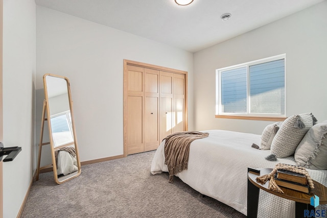 carpeted bedroom featuring a closet and baseboards