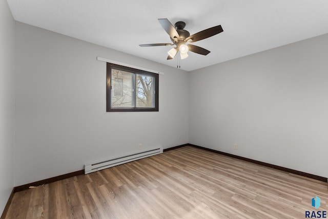 empty room featuring baseboards, a ceiling fan, baseboard heating, and light wood-style floors