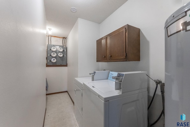laundry room featuring baseboards, cabinet space, a textured ceiling, and washing machine and dryer