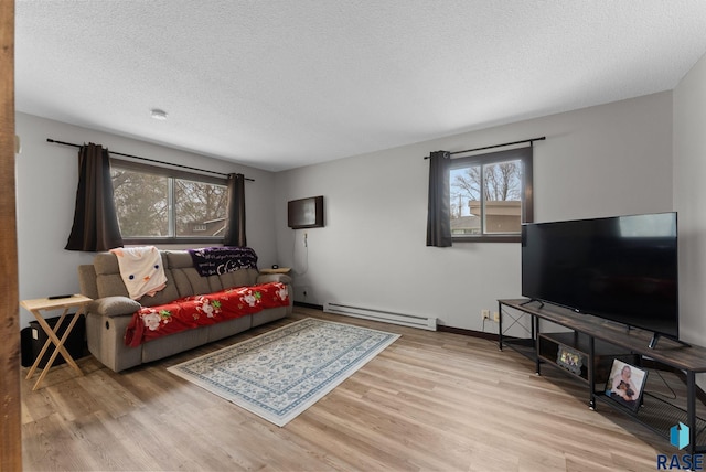 living room with a textured ceiling, wood finished floors, and a baseboard heating unit