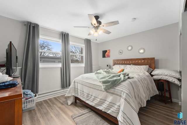 110 N Kimball St, Canton, SD 57013 - bedroom featuring a baseboard heating unit, ceiling fan, wood finished floors, and baseboards