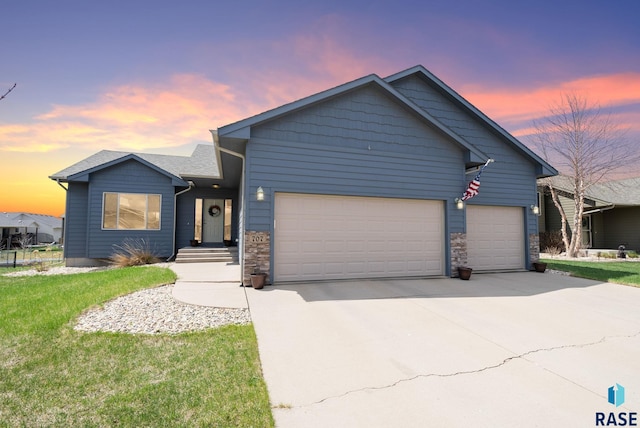 single story home with concrete driveway, a lawn, and a garage