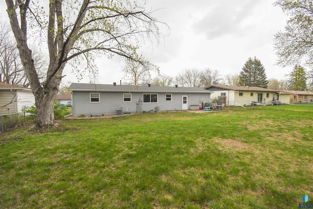 back of property featuring fence and a yard