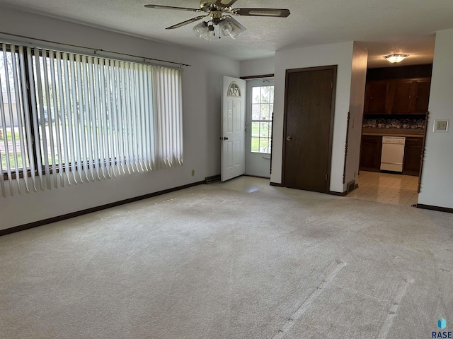 interior space with baseboards, light carpet, and ceiling fan