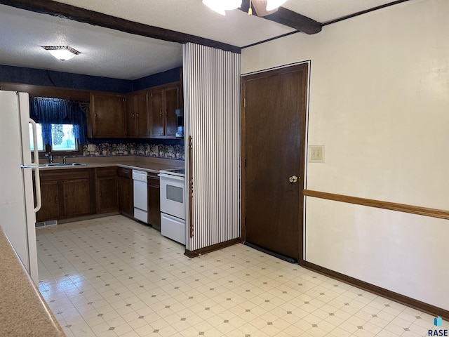kitchen featuring ceiling fan, dark brown cabinets, a sink, light floors, and white appliances