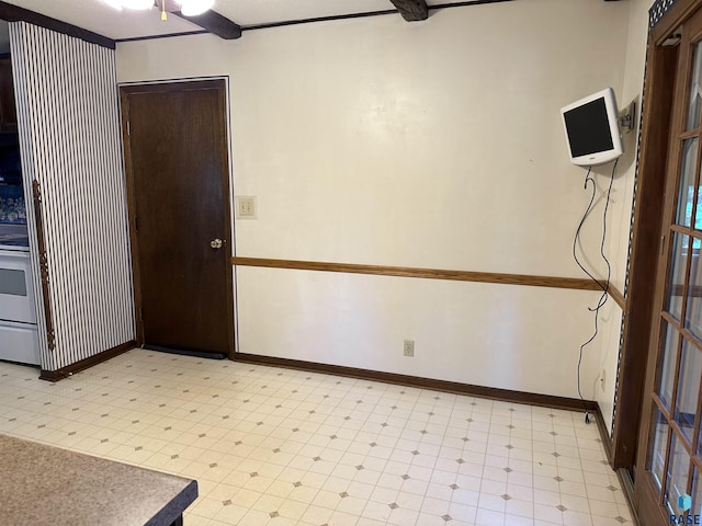 spare room featuring light floors, baseboards, and a ceiling fan