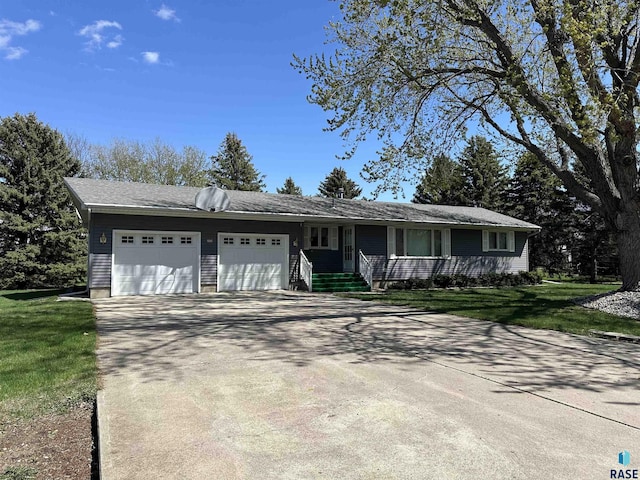 single story home with a porch, a garage, a front yard, and concrete driveway