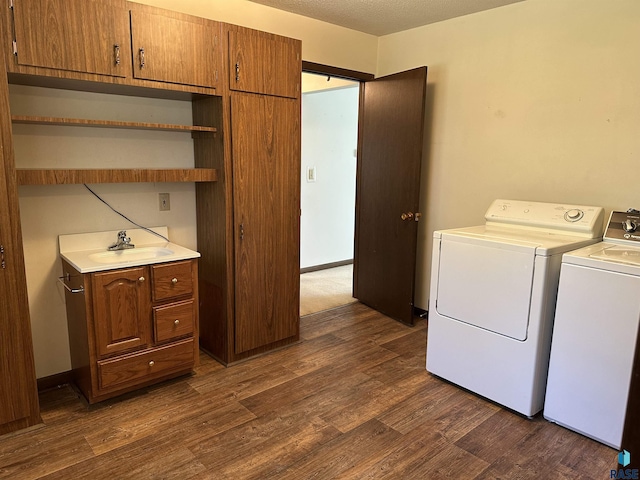laundry area with a sink, dark wood-style flooring, independent washer and dryer, and cabinet space