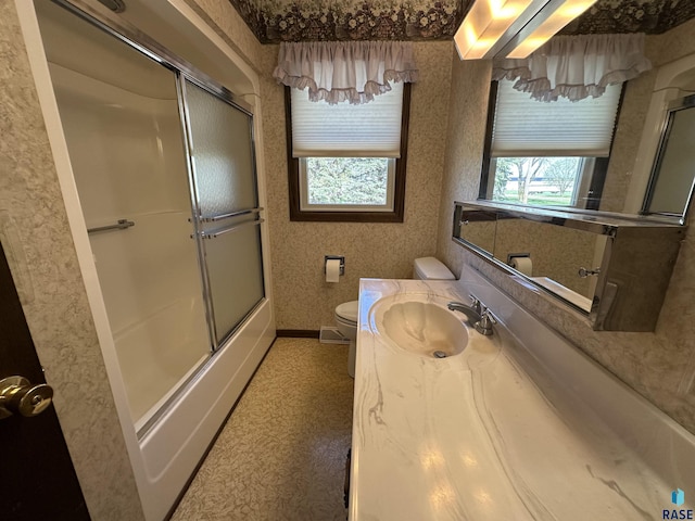 full bathroom featuring vanity, enclosed tub / shower combo, and toilet