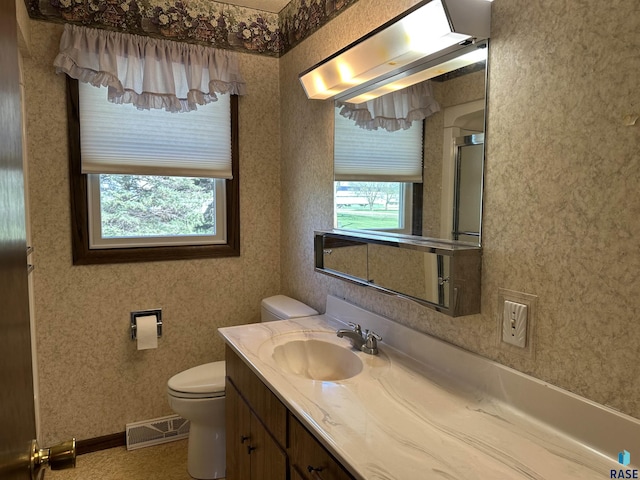 full bathroom with vanity, plenty of natural light, toilet, and visible vents