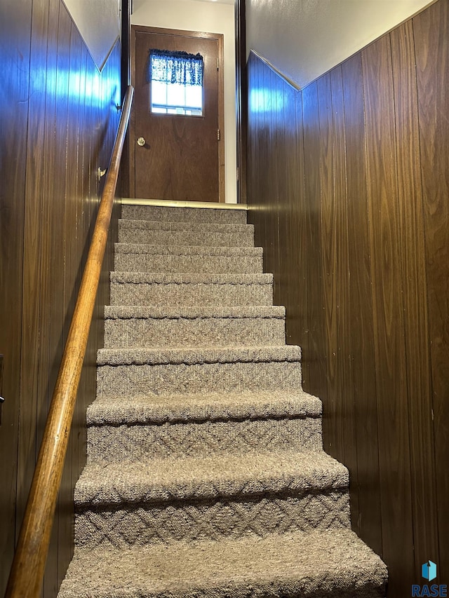 stairs featuring wooden walls