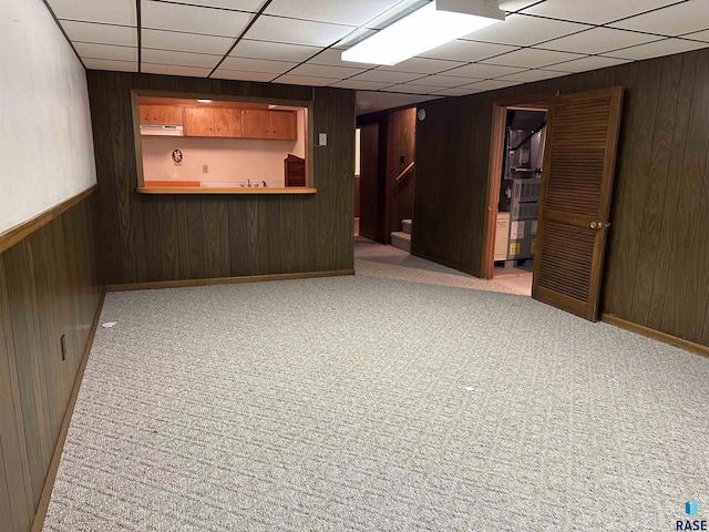 bar featuring wooden walls, a drop ceiling, and carpet floors