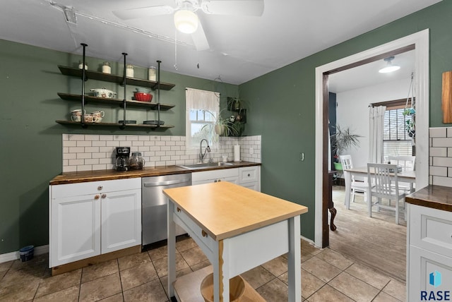 kitchen featuring decorative backsplash, ceiling fan, dishwasher, a sink, and wood counters