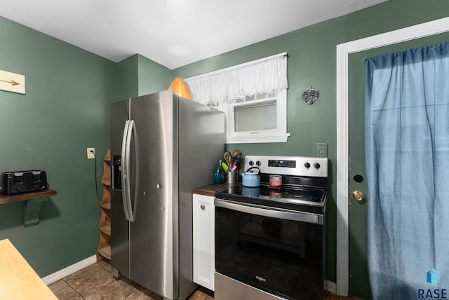 kitchen with baseboards, appliances with stainless steel finishes, and tile patterned floors
