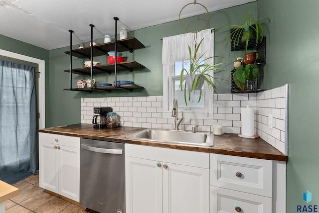 kitchen featuring backsplash, wooden counters, a sink, and dishwasher