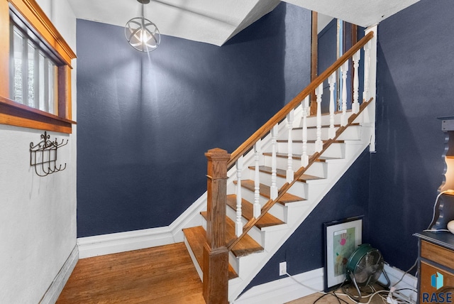stairs with baseboards and wood finished floors