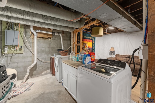 washroom featuring cabinet space, electric panel, and washing machine and clothes dryer