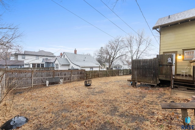 view of yard with a fenced backyard, a deck, and a residential view