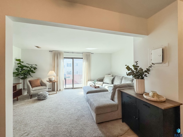 living area featuring light colored carpet and a baseboard radiator