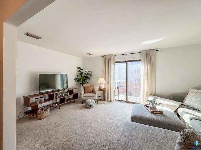 living area featuring carpet flooring, visible vents, and a baseboard radiator
