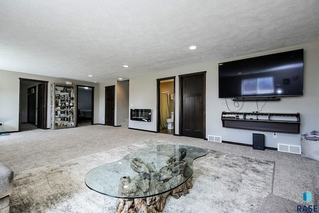 carpeted living room featuring baseboards, recessed lighting, visible vents, and a textured ceiling