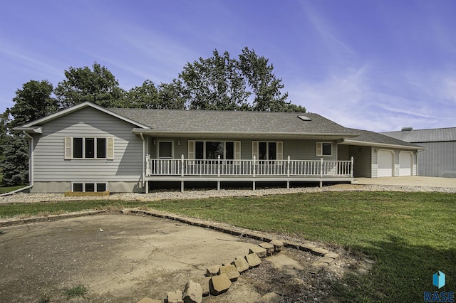 single story home featuring an attached garage, driveway, a front yard, and a porch