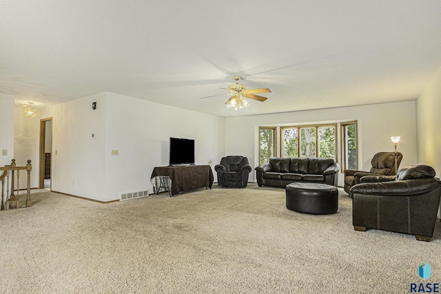 living room with visible vents, baseboards, carpet floors, and ceiling fan